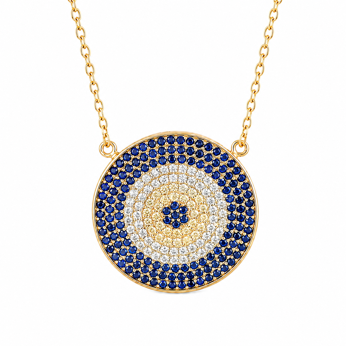 A gold-tone circular pendant necklace featuring concentric evil eye style rings of deep blue, clear, and gold pavé stones, suspended from a gold chain on a white background.