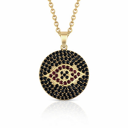 Gold necklace with a round pendant featuring black and red stones on a white background