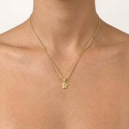 A delicate gold chain necklace with a small star-shaped pendant, shown worn on a model's neck against a clean white background.